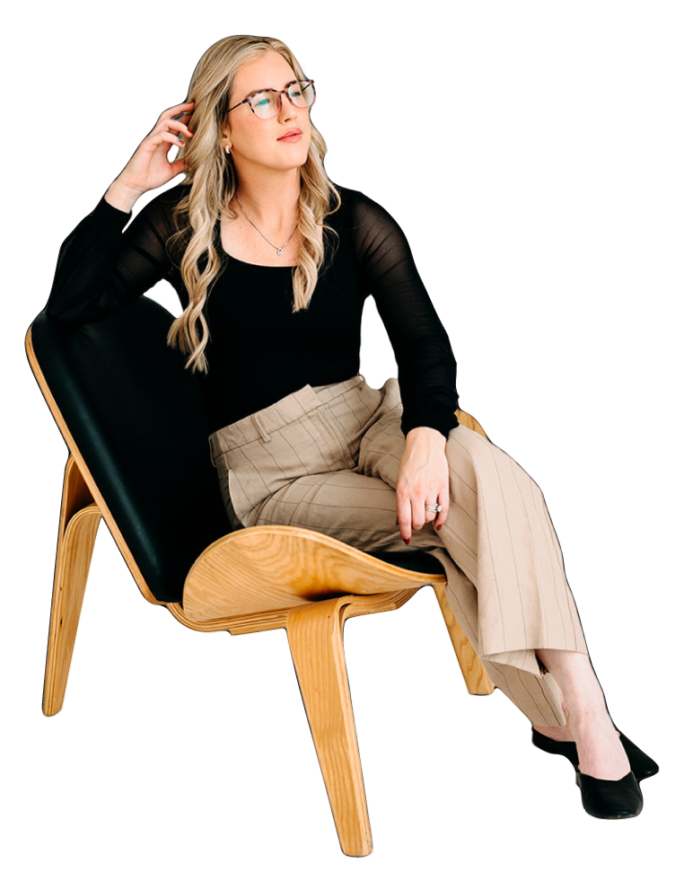 A woman with glasses sits on a modern wooden chair, looking thoughtful.