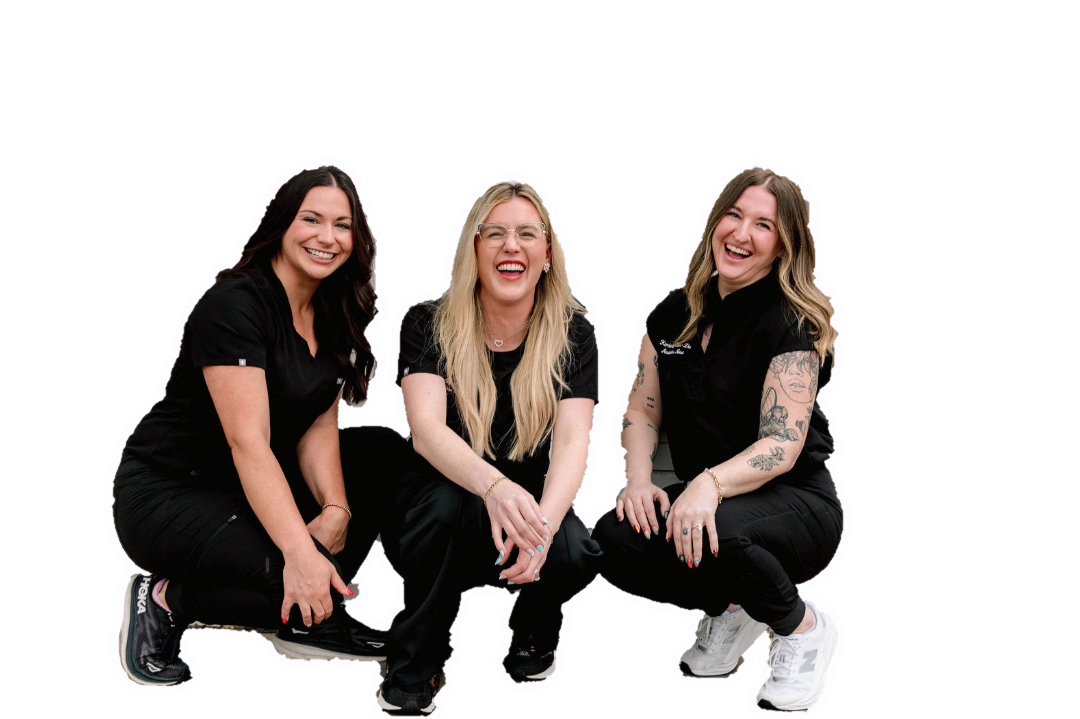 Three women in black outfits squatting and smiling against a white background.